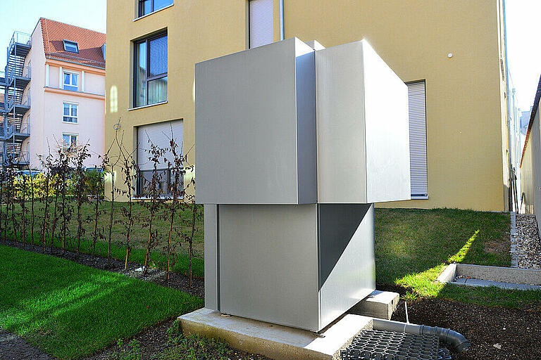 Luftwärmepumpe für Heizung und Warmwasser vor einem Mehrfamili